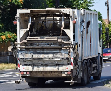 Drivers securing a skip on a truck for safe transport