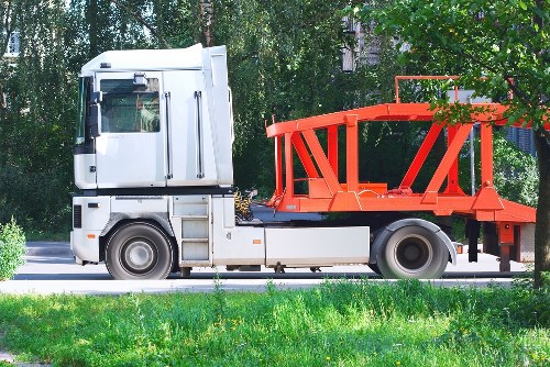 Staff placing a skip with protective equipment visible